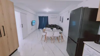 a kitchen with a table and chairs and a refrigerator at STAY Azure Dream Apartment in Paralimni