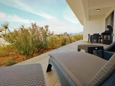 a porch of a house with a table and chairs at Family large apartment in Bahçeli in Aglantzia