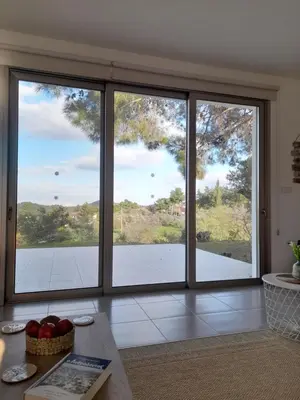 a living room with sliding glass doors with a view at Olive & Pinetree House in Lythrodontas