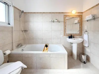 a bathroom with a tub and a sink at Sunny Villa with Hot Tub, Garden and 2 Bedrooms, 5 Minutes to the Beach in Pyla