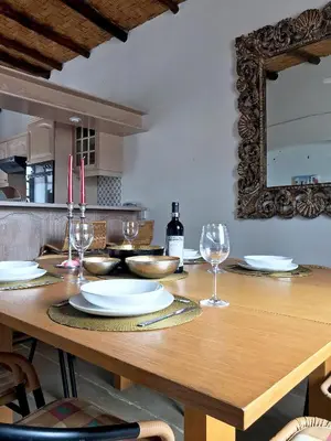 a wooden table with plates and wine glasses on it at Cobblers in Maroni