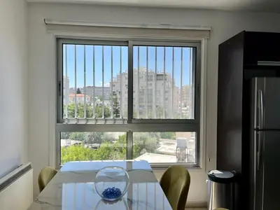 a kitchen with a table and a large window at Cozy Stay Nicosia in Nicosia