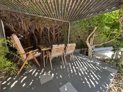 a table and chairs under an umbrella on a patio at 3 Bedroom Oceanfront Oasis for Memorable Vacations in Voroklini