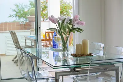 a glass table with a vase with purple flowers on it at Protaras Views Villa PRAM1 in Protaras