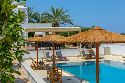 a pool with chairs and umbrellas next to a building at Protaras Views Villa PRAM1 in Protaras
