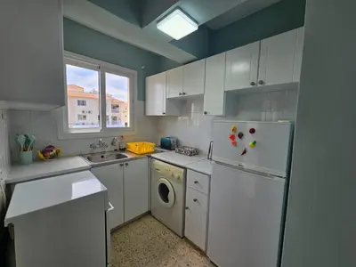 a kitchen with a refrigerator and a washer and dryer at Kapparis - Blue and aqua in Paralimni