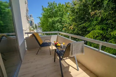 a balcony with two chairs and a table with fruit on it at 1 BDR New Boutique & Prime Location in Limassol