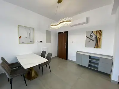 a dining room with a white table and chairs at 1 bedroom 104 in Limassol