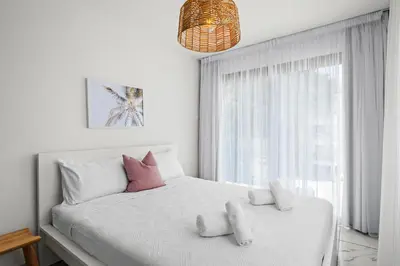 a bedroom with a white bed with two stuffed animals on it at Majan Residences in Larnaka