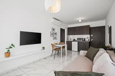 a white living room with a couch and a table at Majan Residences in Larnaka