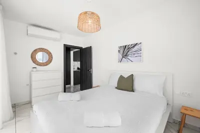 a white bedroom with a large white bed at Majan Residences in Larnaka