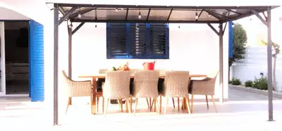 a table and chairs under a gazebo at Villa Elia Blue , hot tube , heated pool in Paralimni