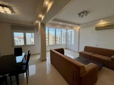 a living room with a couch and a table and some windows at Sunny Stay 2 Bdr near the sea Platform 357 in Limassol