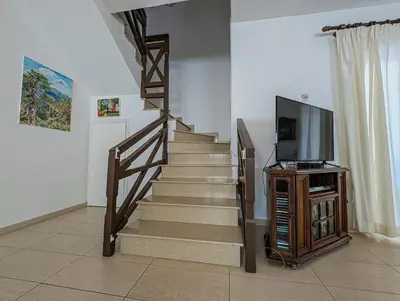 a living room with a staircase with a tv at Fig Tree Bay Villa Elena in Protaras
