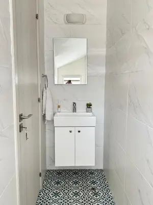 a white bathroom with a sink and a mirror at Villa Jarvis Modern and Quiet 3BR with Private Swimming Pool in Paralimni