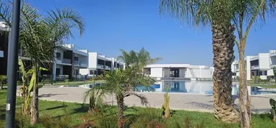 a resort with a swimming pool and palm trees at Modern Luxury Apartment in Aglantzia