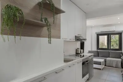 a kitchen with white cabinets and green plants in it at Seabreeze Residence by Staycom in Larnaka