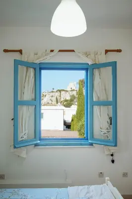 a blue window in a bedroom with a view at L'Azure 24 - Protaras in Paralimni