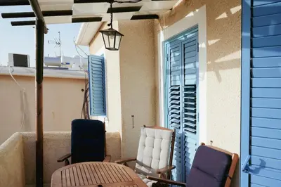 a balcony with chairs and a table and a window at L'Azure 24 - Protaras in Paralimni