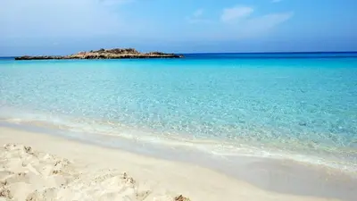 a beach with an island in the middle of the ocean at Mediterraneo 27 - Protaras in Protaras