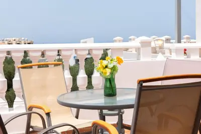 a vase of flowers sitting on a table on a balcony at STAY Kali Sun Apartment in Paralimni