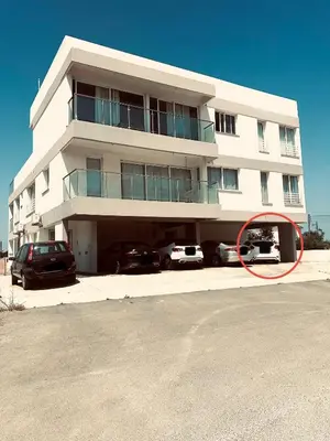 a large white building with cars parked in front of it at Serene Getaway Near Protaras in Paralimni