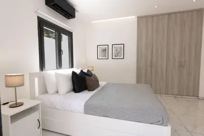 a white bedroom with a large bed and a window at Kakopetria Luxury Villa w pool in Kakopetria