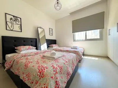 a bedroom with two beds and a mirror at Albert's Apartment Center 203B in Larnaka