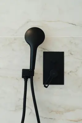 a black microphone on a tripod next to a lightswitch at Infinity Residences in Zygi