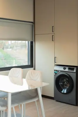 a kitchen with a washing machine and a table and chairs at Infinity Residences in Zygi