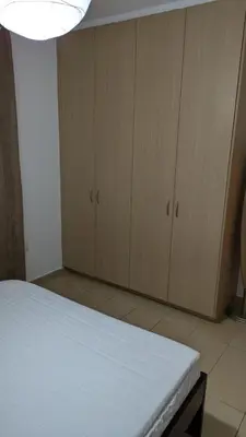 a room with a bed and wooden cabinets at Pool flat near Ayia Napa in Sotira
