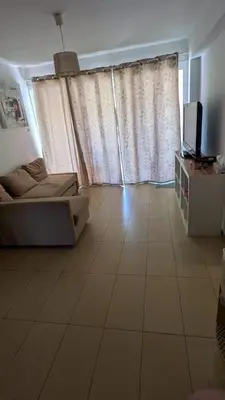 a living room with a couch and a television at Pool flat near Ayia Napa in Sotira