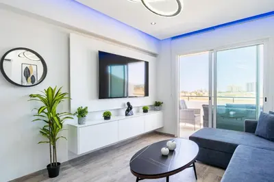 a living room with a blue couch and a tv at Olympus Stylish 2-BR Apt & Balcony in Larnaca in Larnaka