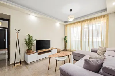 a living room with a couch and a tv at Downtown Finikoudes Beach Apartment in Larnaka