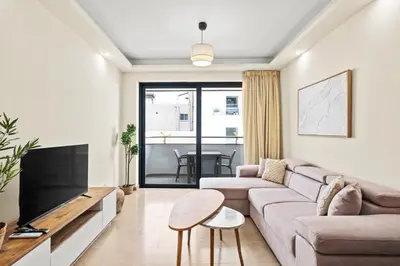 a living room with a couch and a table at Downtown Finikoudes Beach Apartment in Larnaka
