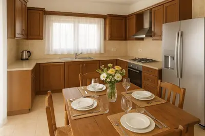 a kitchen with a wooden table with plates and flowers at Eros Villa-Private Luxury Estate in Pissouri