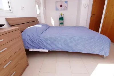 a bedroom with a bed with a blue blanket at Maouris Villa in Protaras
