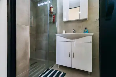 a bathroom with a white sink and a shower at Central Cosy Comfort Suite in Nicosia
