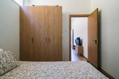 a bedroom with a large wooden cabinet next to a bed at Central Cosy Comfort Suite in Nicosia
