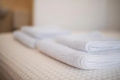 a group of white towels stacked on a bed at Villa Lela in Paralimni