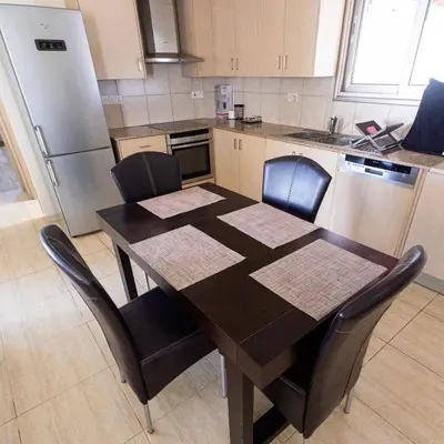 a kitchen with a table with chairs and a refrigerator at Maestro Villa II - Pervolia in Pervolia
