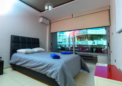 a bedroom with a bed and a large window at City Center Flat 23 in Larnaka