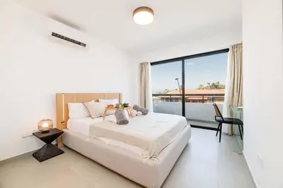 a bedroom with a large bed and a large window at Finikoudes Marina View 102 in Larnaka