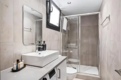 a bathroom with a white sink and a shower at Finikoudes Marina View 102 in Larnaka