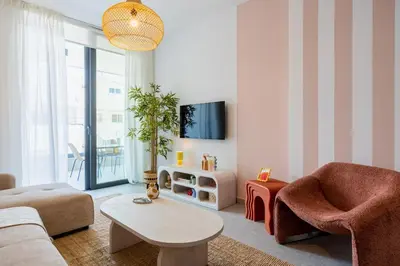 a living room with a couch and a tv at Lunette - Artful 1-BR Apartment & Balcony in Larnaca in Larnaka