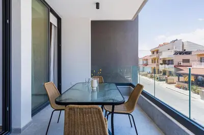 a dining room with a table and chairs and a window at Lunette - Artful 1-BR Apartment & Balcony in Larnaca in Larnaka