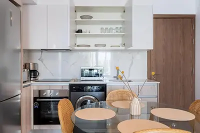 a kitchen with a table and chairs and a microwave at Lunette - Artful 1-BR Apartment & Balcony in Larnaca in Larnaka