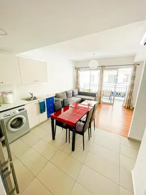 a kitchen and living room with a red table and chairs at Awaken Your Hidden Goddess Retreat at Nissi Avenue - Central Ayia Napa in Ayia Napa