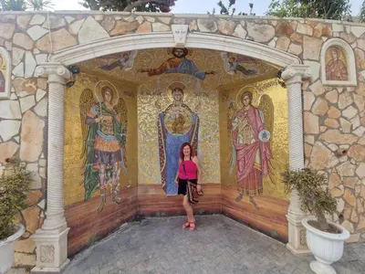 a woman standing in front of a wall with mosaics at Awaken Your Divine Self Sacred Self Discovery Retreat in Ayia Napa Cyprus in Ayia Napa