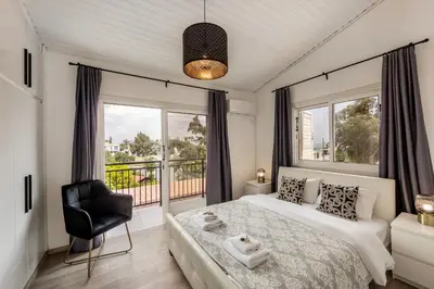 a bedroom with a bed and a chair and windows at Larnaca Seaside Villa Marina 44 in Pervolia